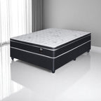 Black and white mattress set on a white floor with gray walls