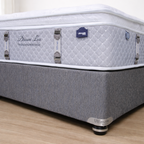 Gray mattress with 'Dream Lux' branding on a wooden floor