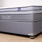 Gray mattress with 'Dream Sleeper' branding on a wooden floor.