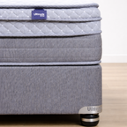 Gray mattress with a visible brand label on a wooden floor