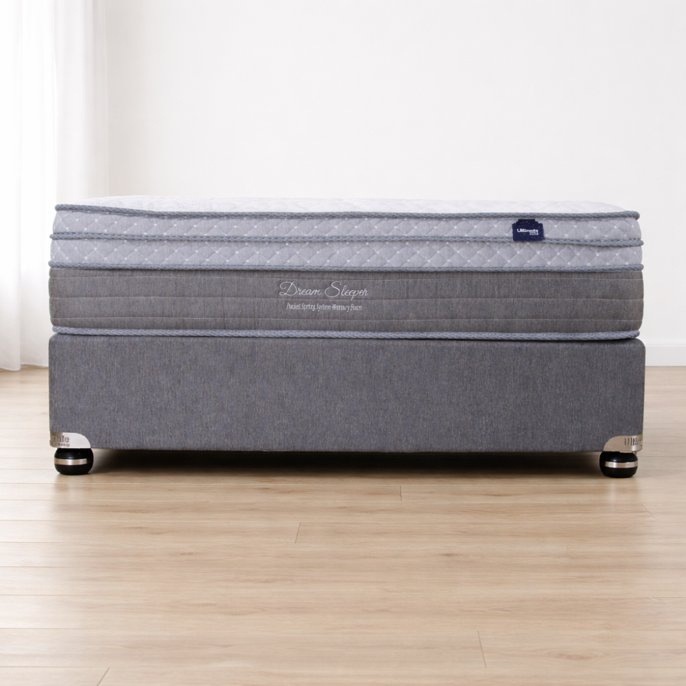 Gray mattress with a visible brand logo on a wooden floor.