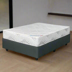 A queen-sized mattress set with a patterned top sheet, solid-colored bottom sheet, and a charcoal fabric upholstered base, all displayed on a white background.