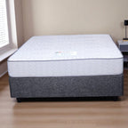 Mattress on a wooden floor with a neutral wall background