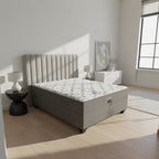 Gray upholstered bed with tufted headboard in a bedroom setting