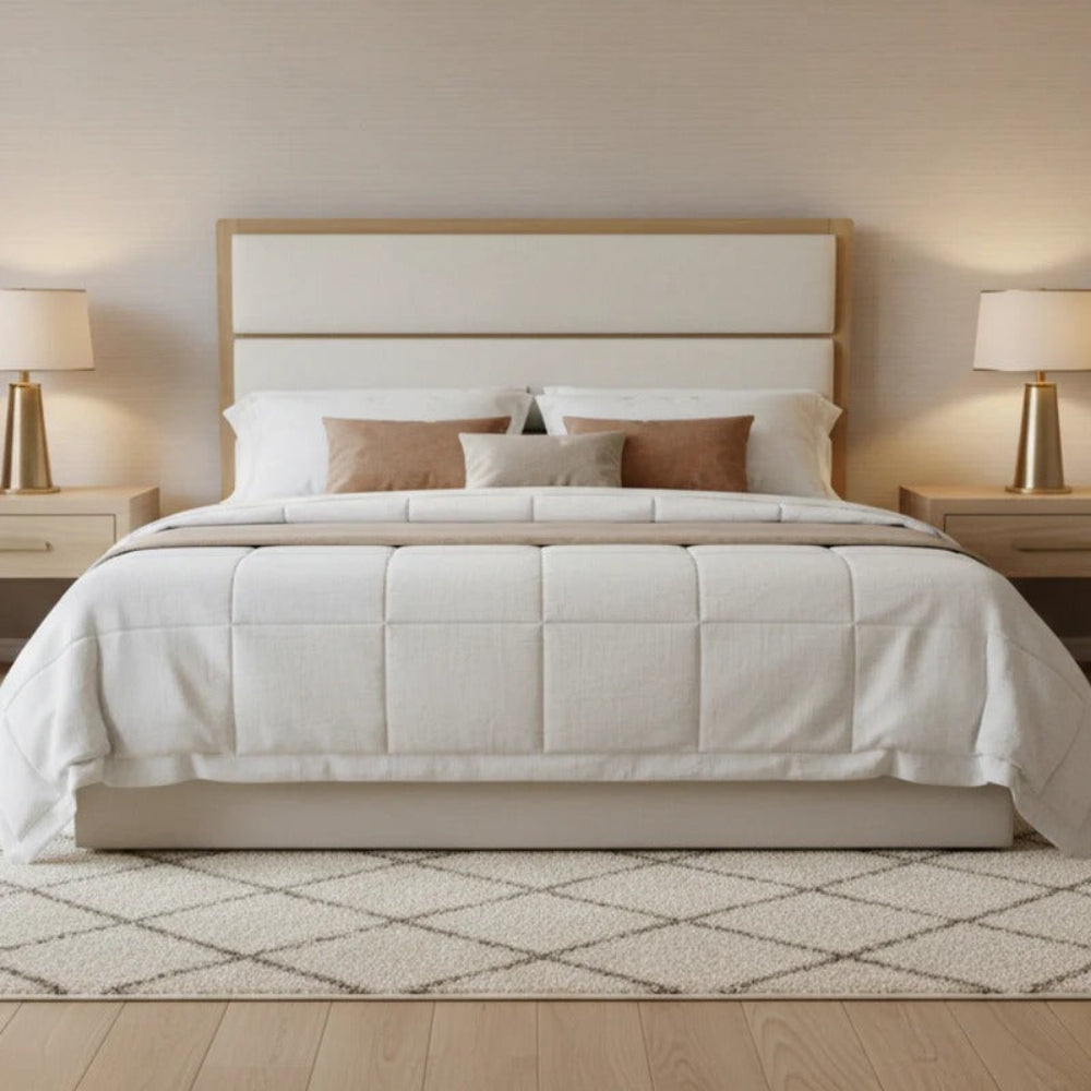 Neatly made bed with beige bedding and pillows in a bedroom setting.